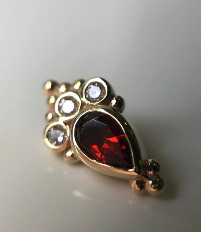 BVLA - Pear Sarai featuring Garnet pear(AA) with white diamonds ( VS) accents in solid yellow gold.